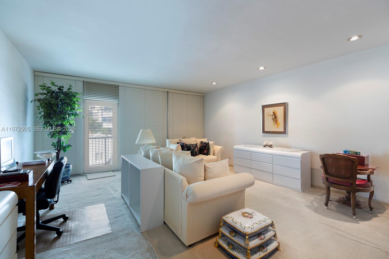 A living room features a sofa, a white dresser, a desk, and a balcony door — 1408 Brickell Bay Dr # 414, Miami FL 33131, MIAMI, FL