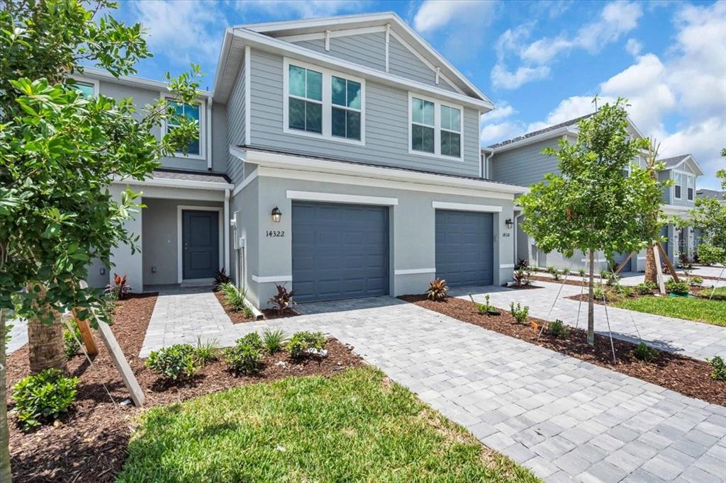 A two-story gray townhouse with a two-car garage and a paved driveway — 14322 LILAC SKY TERRACE, BRADENTON, FL