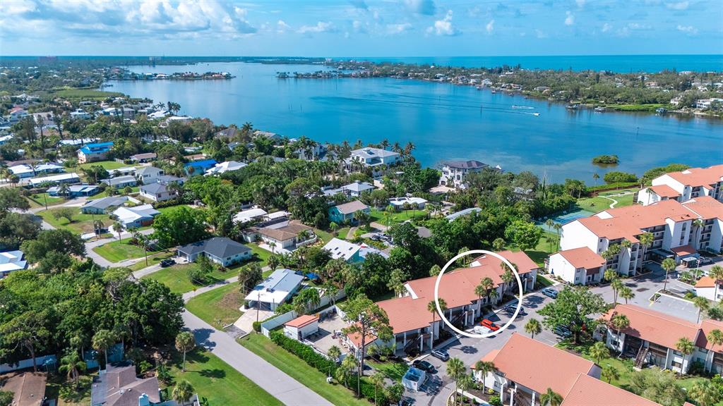 An aerial view of a residential complex with a circled multi-story building near water — 1646 STICKNEY POINT ROAD UNIT 101, SARASOTA, FL