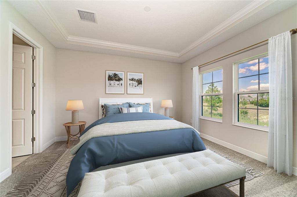 A bedroom features a blue bed, a white bench, two windows, and neutral carpeting — 35517 STABLETON LANE, ZEPHYRHILLS, FL
