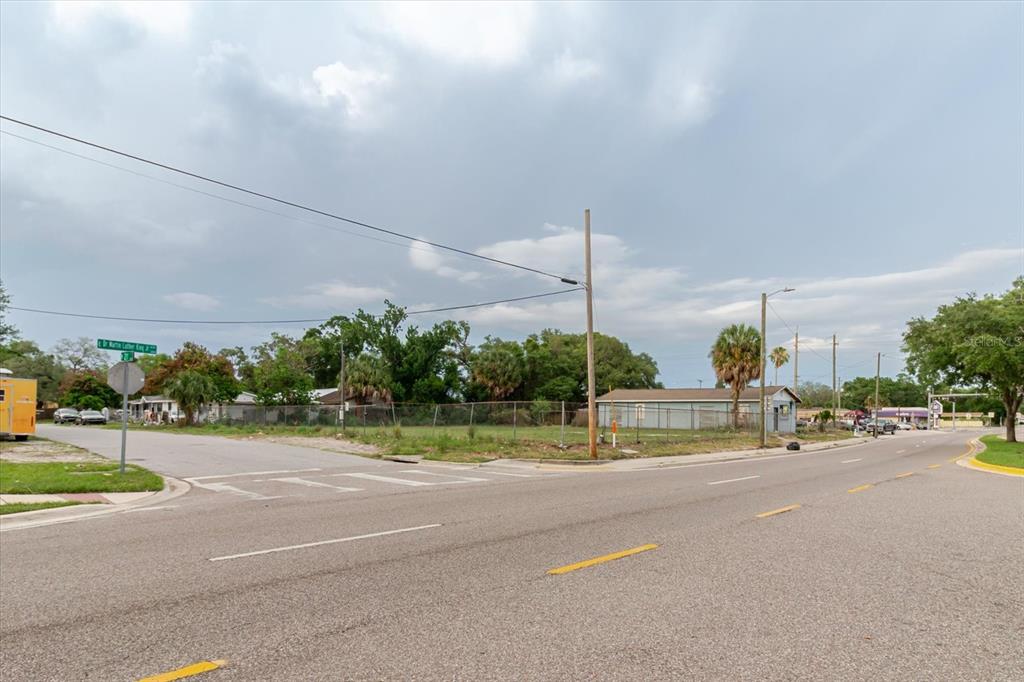 A vacant corner lot is enclosed by a chain-link fence near a paved intersection — 2104 E DR MLK, TAMPA, FL