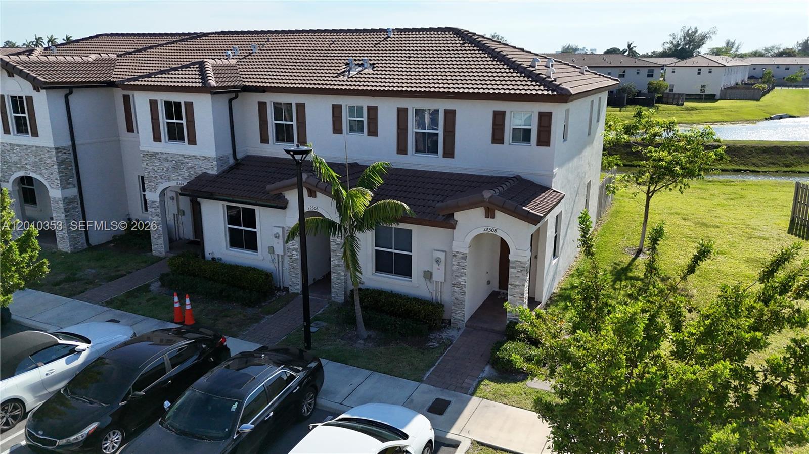 An aerial view shows the exterior of a multi-unit townhouse building with a tiled roof — 12308 NW 23rd Ct # 12308, Miami FL 33167, MIAMI, FL