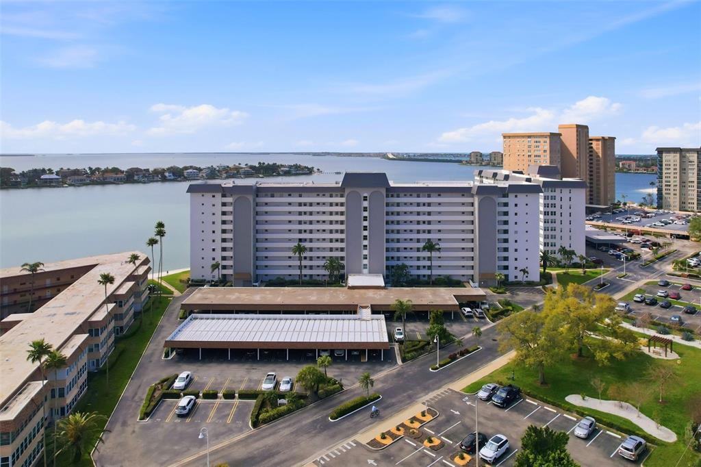 An aerial view shows a multi-story apartment complex with parking lots and a waterfront location — 5108 BRITTANY DRIVE S UNIT 1006, ST PETERSBURG, FL