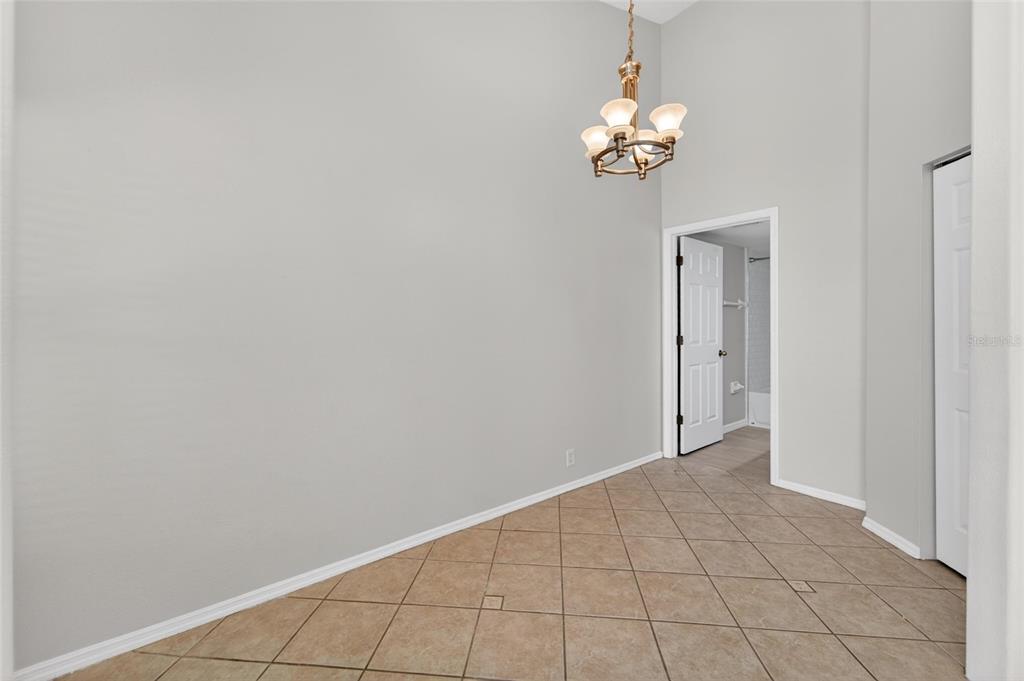 A room with light gray walls, tile flooring, and a hanging chandelier — 658 GREEN VALLEY ROAD UNIT B3, PALM HARBOR, FL