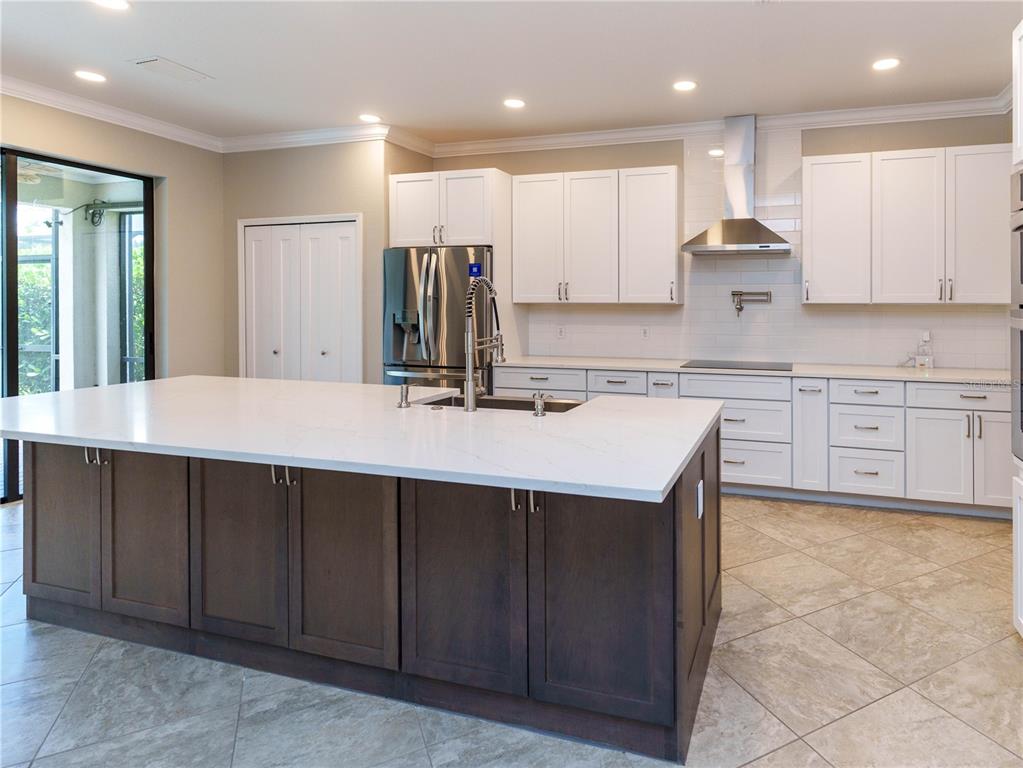 A screened-in swimming pool and spa with a brick paver deck and tropical landscaping — 1588 VIZCAYA LANE, NAPLES, FL