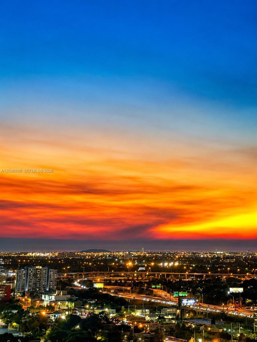 A high-angle view of a city skyline under a vibrant sunset sky — 3301 NE 1st Ave # H2113, Miami FL 33137, MIAMI, FL