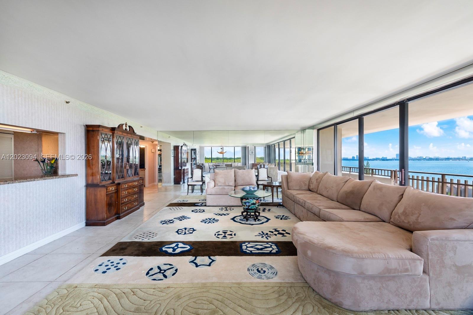 A spacious living room features a large sectional sofa, patterned area rug, and floor-to-ceiling windows — 11113 Biscayne Blvd # 751, Miami FL 33181, MIAMI, FL