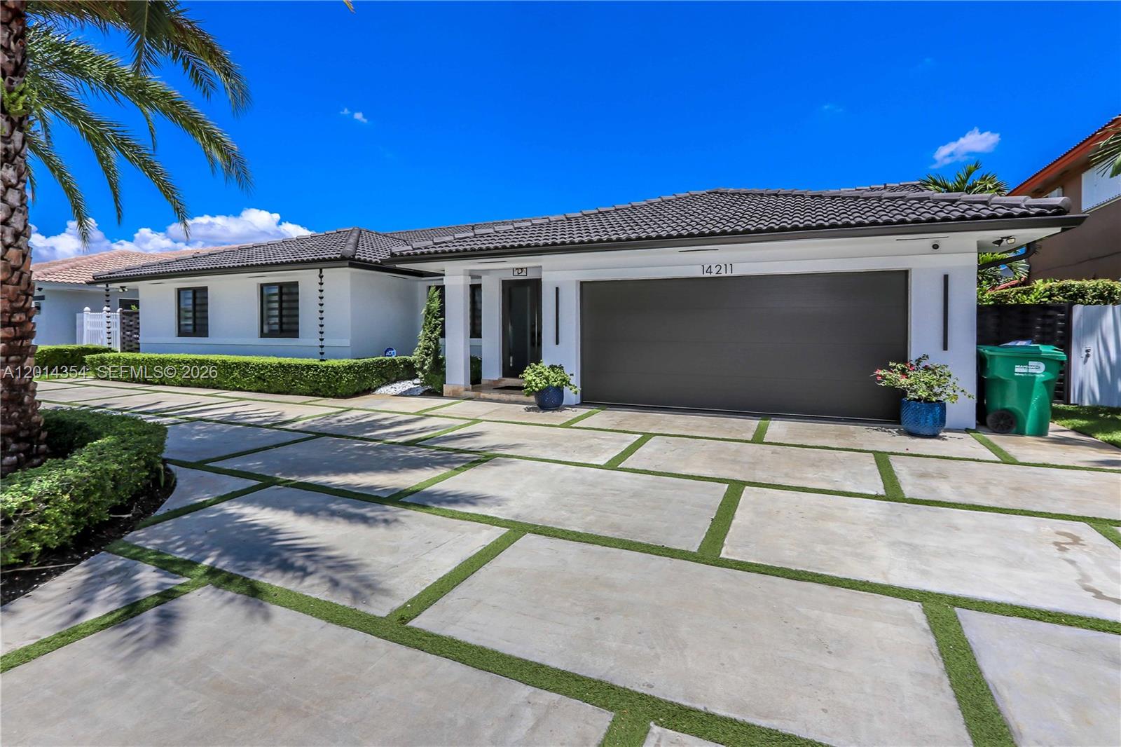A single-story house features a modern concrete paver driveway with grass strips and a garage — 14211 SW 31st St, Miami FL 33175, MIAMI, FL