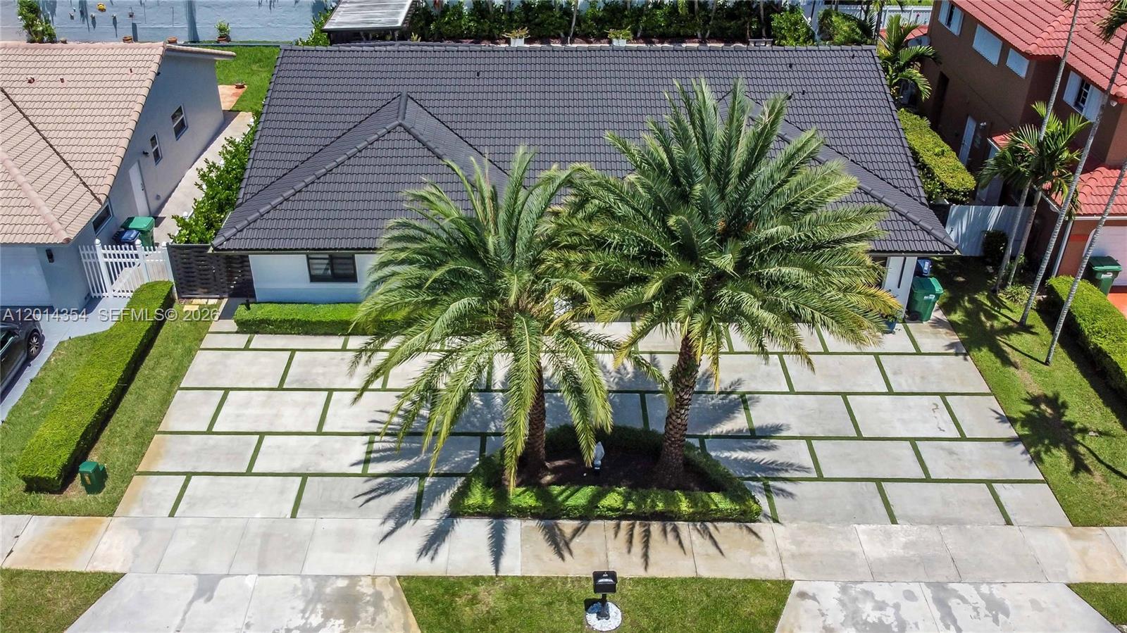 An aerial view of a house with a large paved driveway and two palm trees — 14211 SW 31st St, Miami FL 33175, MIAMI, FL