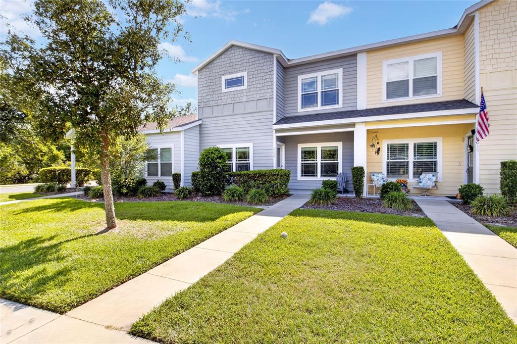 A two-story townhouse with gray and yellow siding features a lawn and concrete walkways — 5008 NW 21ST DRIVE, GAINESVILLE, FL