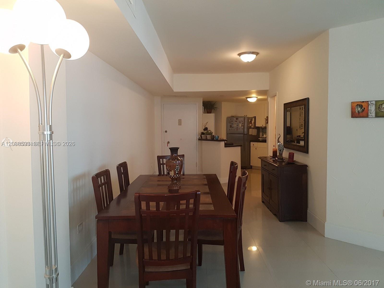 A dining room features a dark wood table with six chairs and a matching sideboard — 801 Brickell Bay Dr # 765, Miami FL 33131, MIAMI, FL