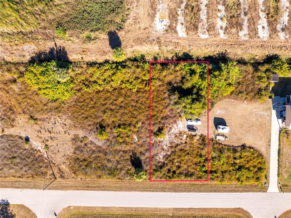 An aerial view shows a rectangular, undeveloped plot of land outlined in red — 29028 BOYCE ROAD, PUNTA GORDA, FL