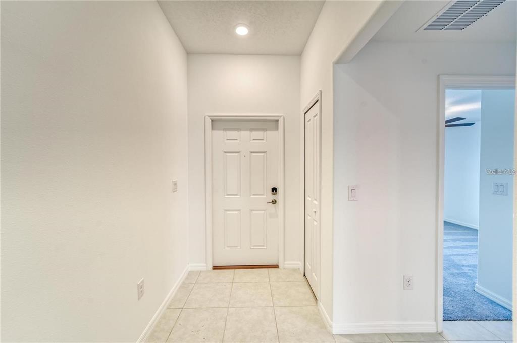 An entryway features a white front door, a closet, and light-colored tile flooring — 5514 BLUE AZURE DRIVE, WIMAUMA, FL