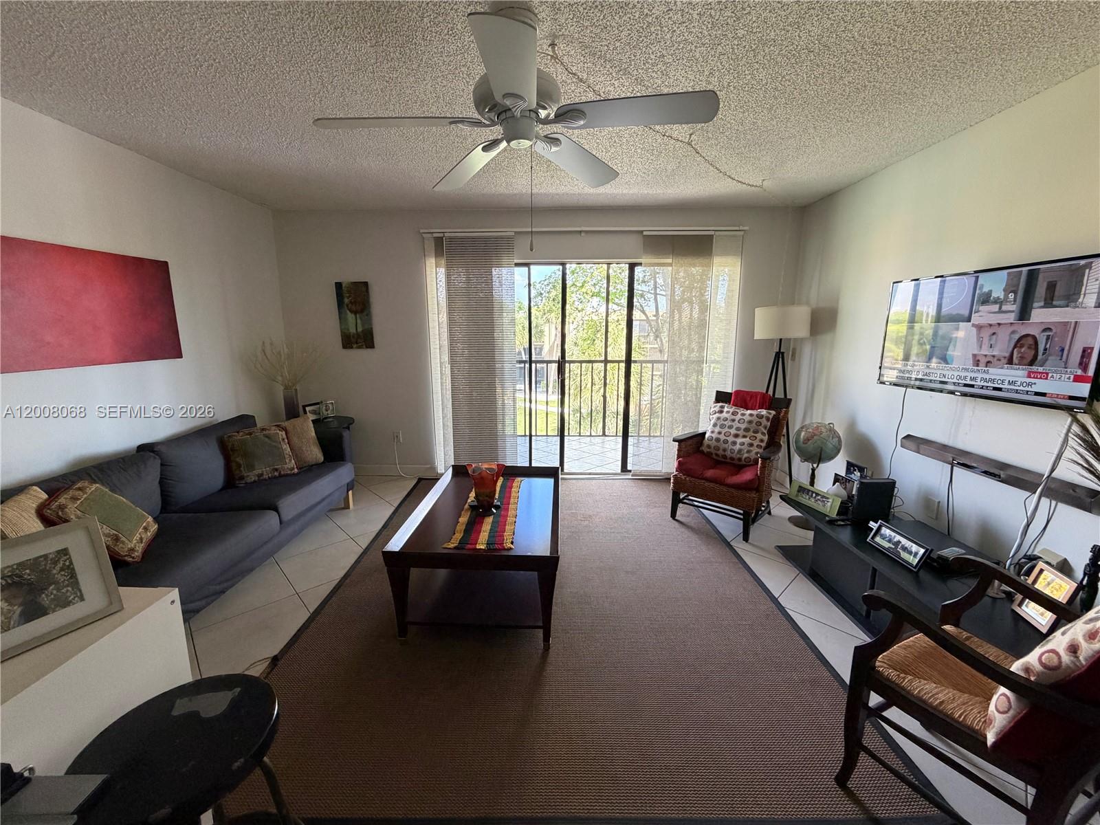 A living room features a gray sofa, a coffee table, a ceiling fan, and a balcony — 8415 SW 107th Ave # 369W, Miami FL 33173, MIAMI, FL