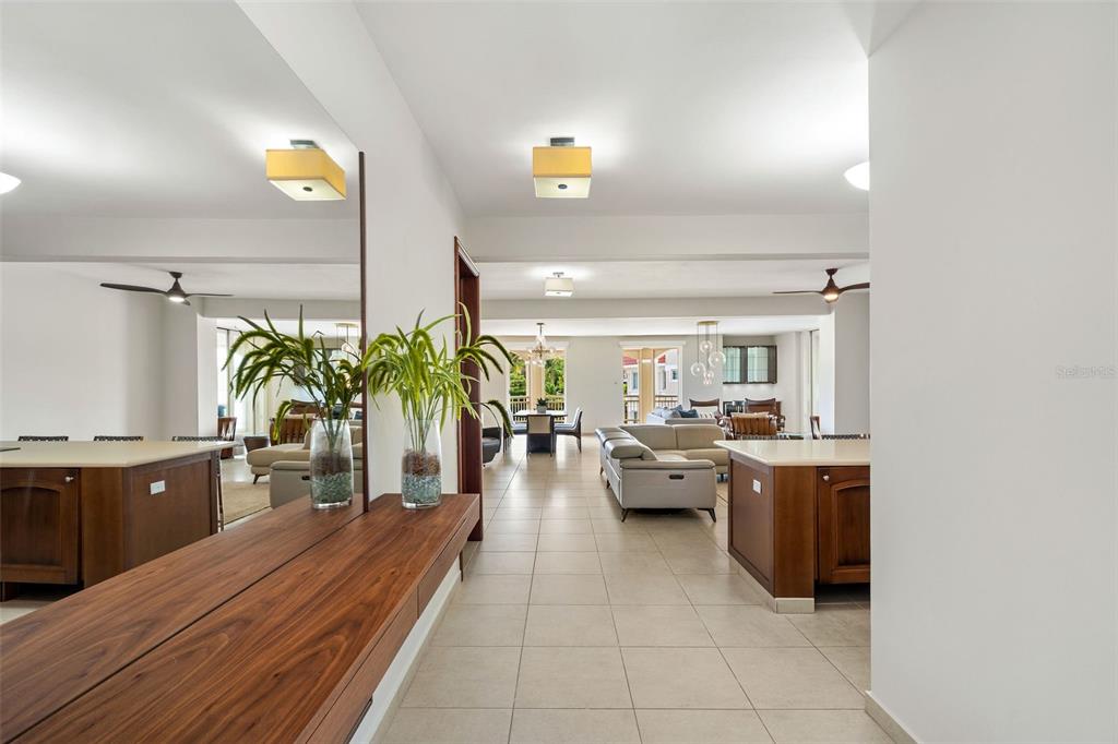 A hallway with a wooden console table and mirror leads into an open-concept living area — 355 HARBOUR DR UNIT 3C - South, HUMACAO, PR