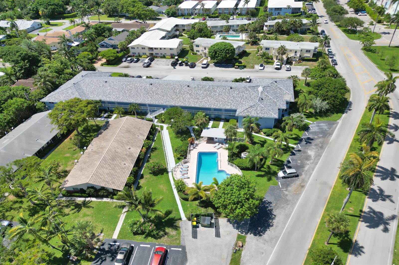 An aerial view shows a multi-story apartment building with a swimming pool and parking lot — 2734 NE 27th Court # 17, Lighthouse Point FL 33064, LIGHTHOUSE POINT, FL