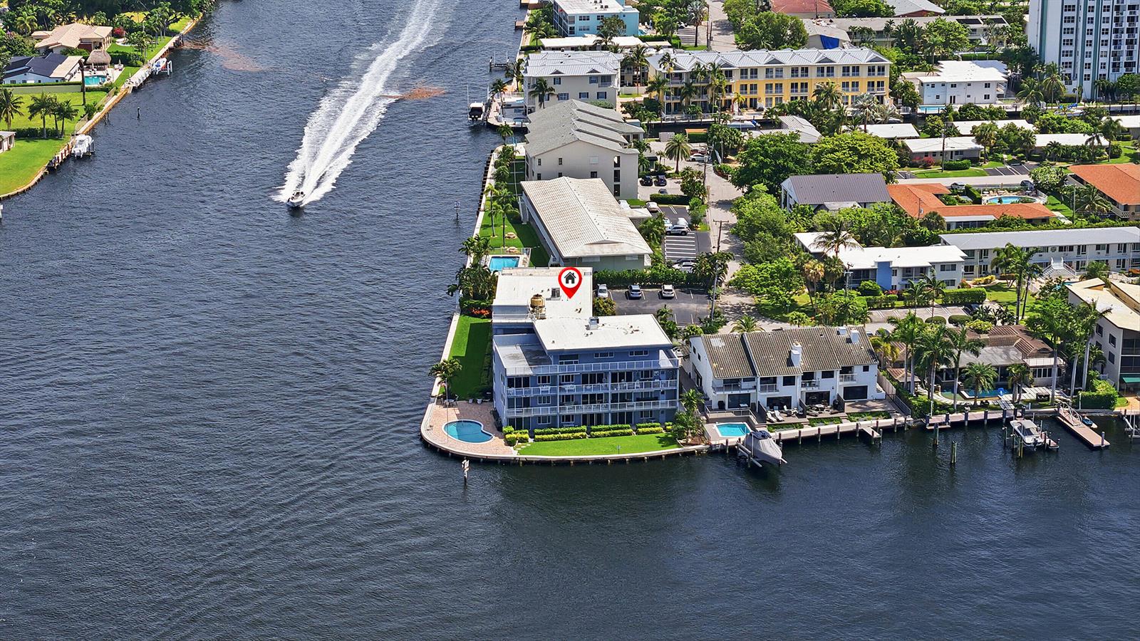 An aerial view shows a waterfront apartment building with a pool and boat docks — 1201 S Riverside Drive # 306, Pompano Beach FL 33062, POMPANO BEACH, FL