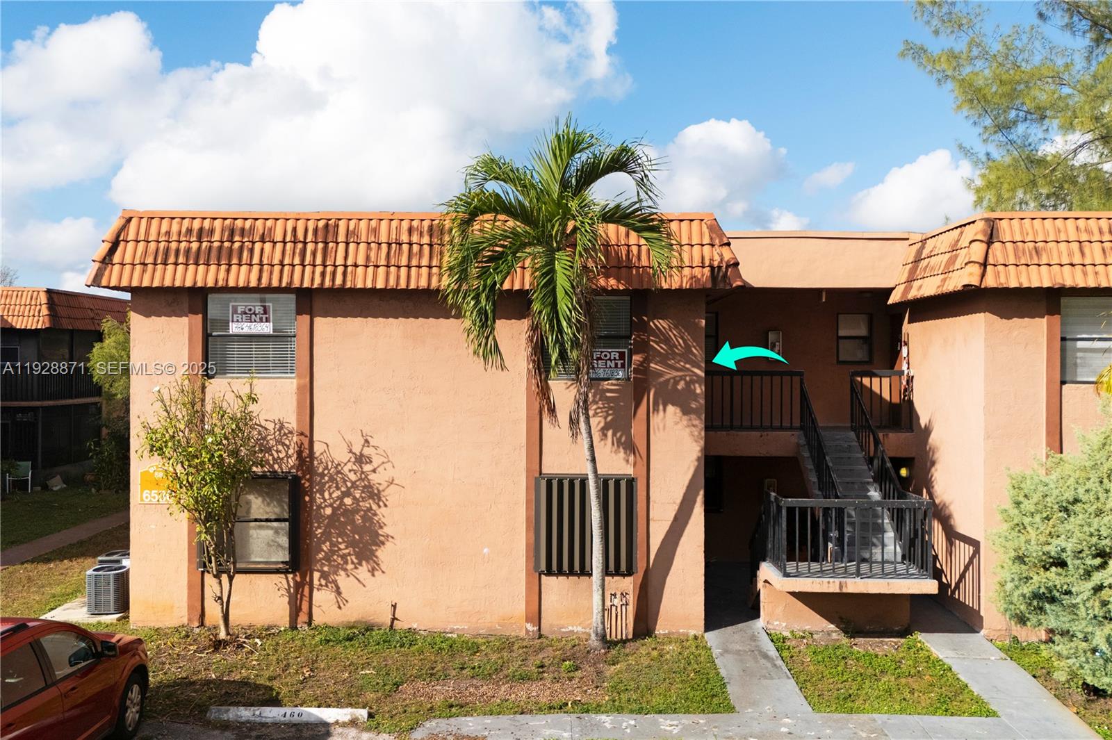 An exterior view of a two-story apartment building with a staircase and a palm tree — 6580 W 27th Ct # 21, Hialeah FL 33016, HIALEAH, FL