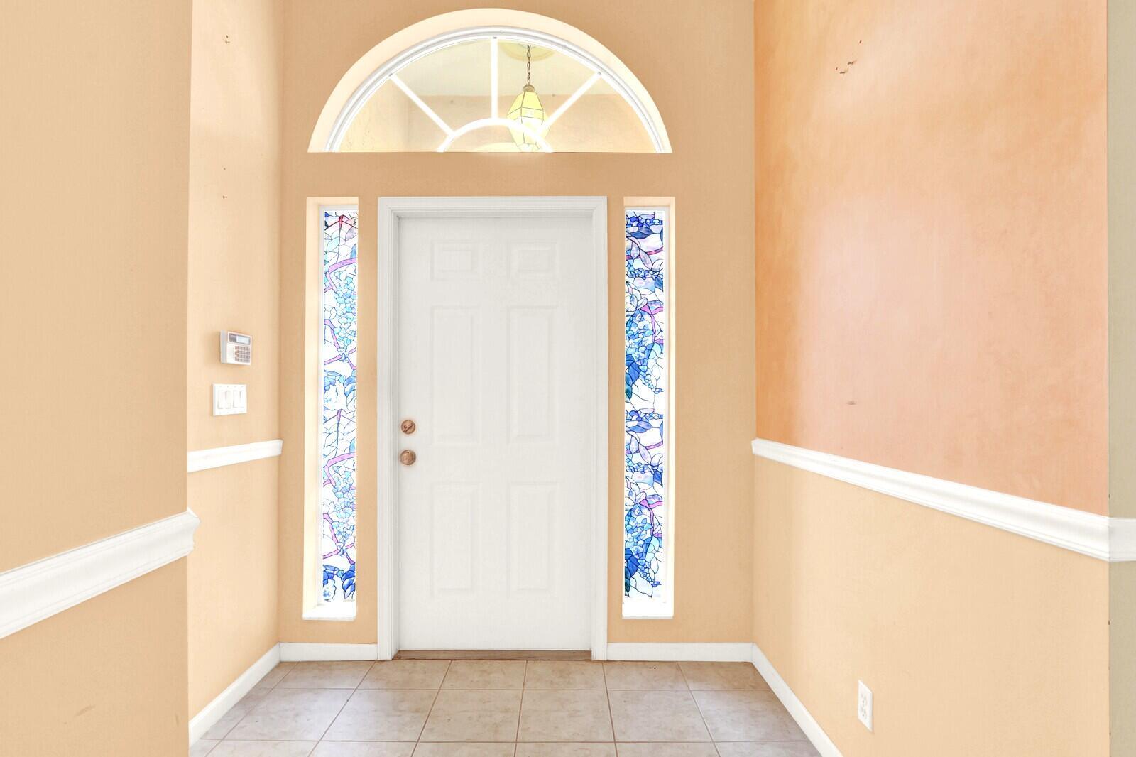 An entryway features a white front door with stained glass sidelights and an arched transom — 3167 El Camino, West Palm Beach FL 33409, WEST PALM BEACH, FL