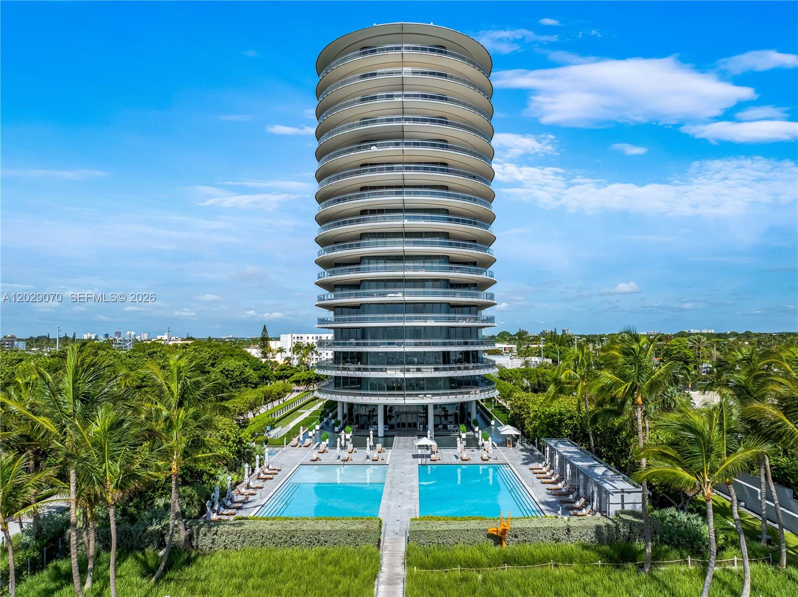 An aerial view shows a cylindrical high-rise residential building with wrap-around balconies and two pools — 8701 Collins Ave # 605, Miami Beach FL 33154, MIAMI BEACH, FL