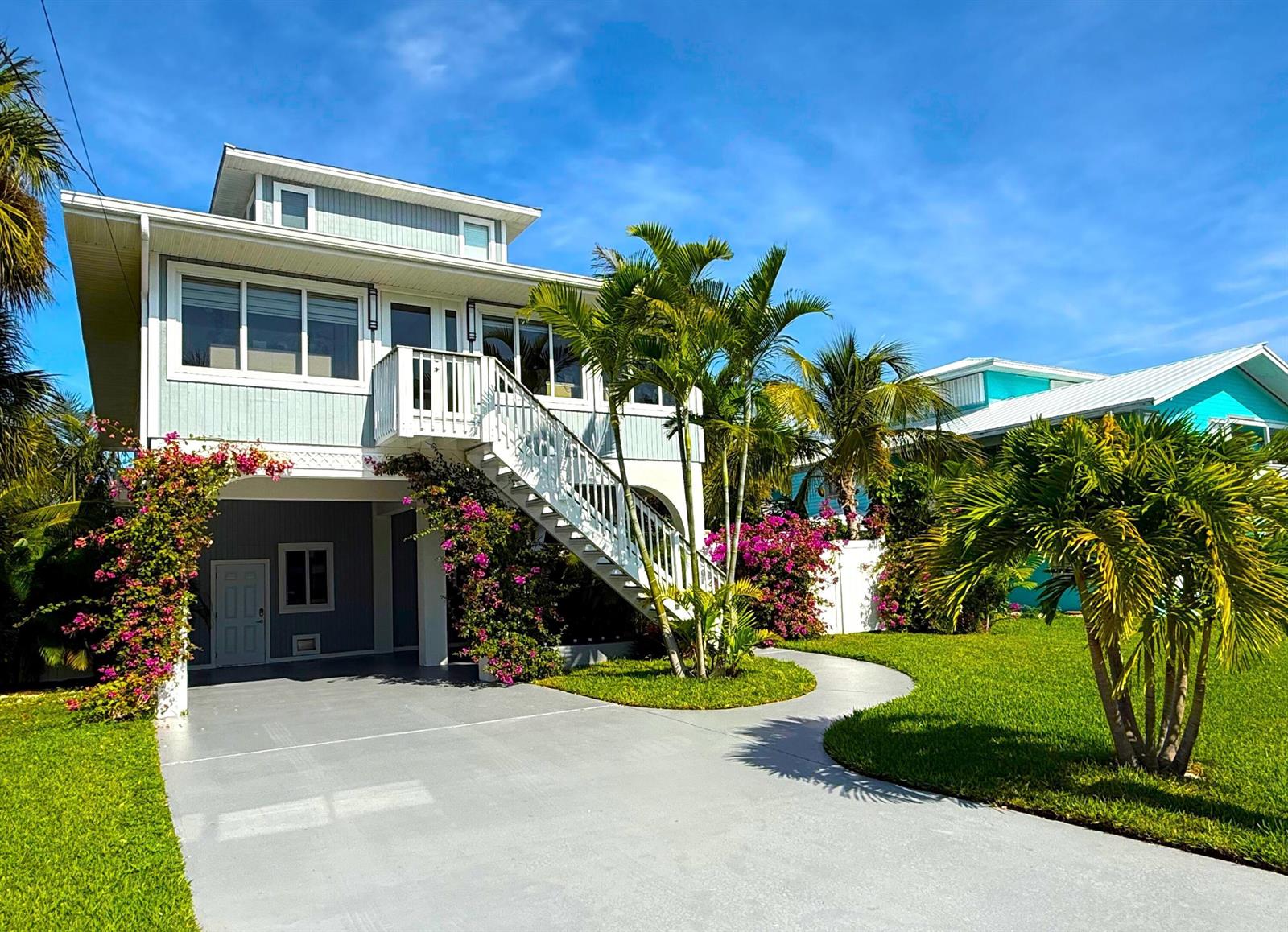 A two-story house with light blue siding, an exterior staircase, and a concrete driveway — 27385 Saint Lucie Lane, FL 33042, FL