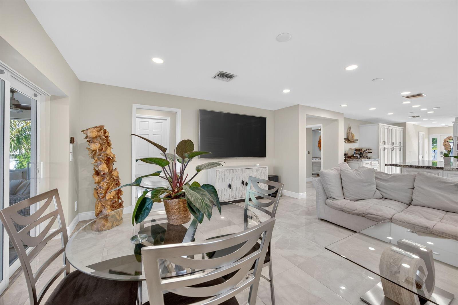 A living and dining area features tile floors, a glass table, and a wall-mounted television — 27385 Saint Lucie Lane, FL 33042, FL