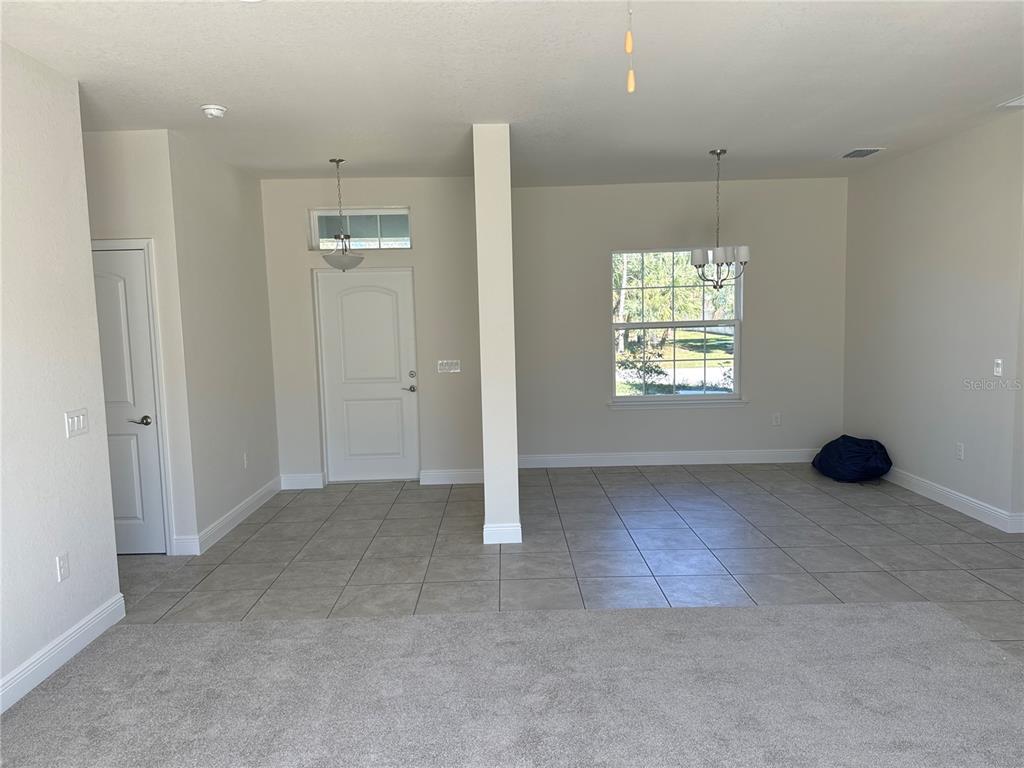 An entryway and dining area with tile flooring, a central pillar, and a front door — 1449 MARJORIE LANE, NORTH PORT, FL