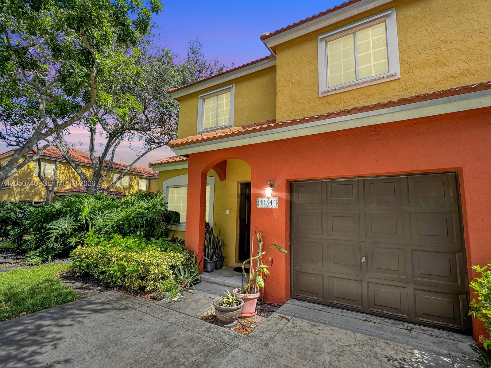A two-story house with an orange and yellow stucco exterior and a brown garage door — 10341 SW 18th St, Miramar FL 33025, MIRAMAR, FL