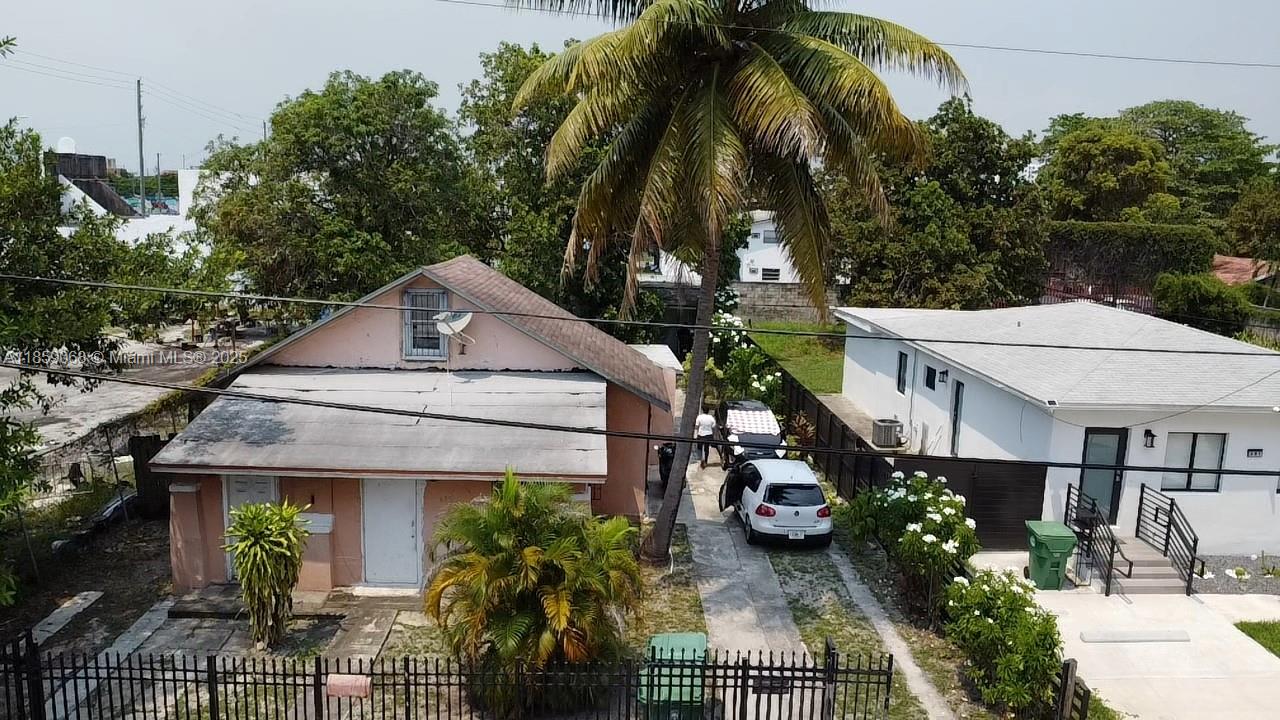 An exterior view of a pink house and a white house with a shared driveway — 683 NW 30th St, Miami FL 33127, MIAMI, FL