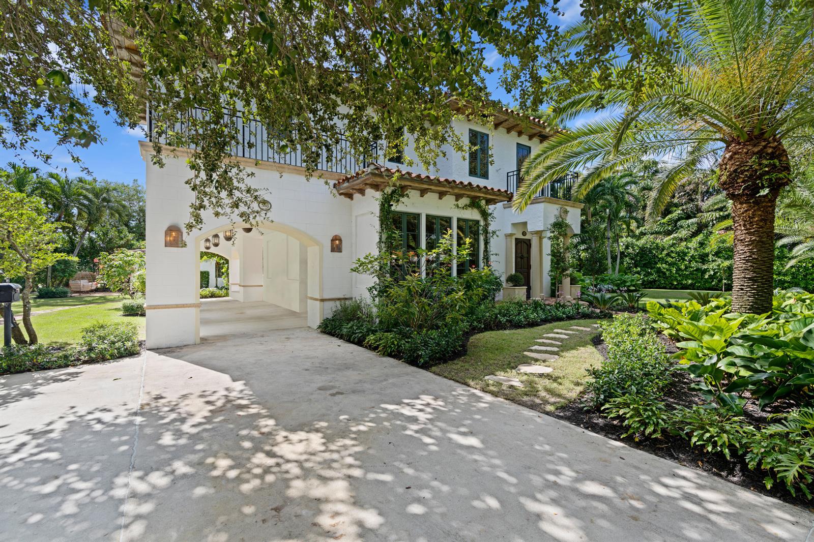 A two-story white stucco house features a covered driveway archway, a tile roof, and landscaping — 308 BARCELONA Road, West Palm Beach FL 33401, WEST PALM BEACH, FL