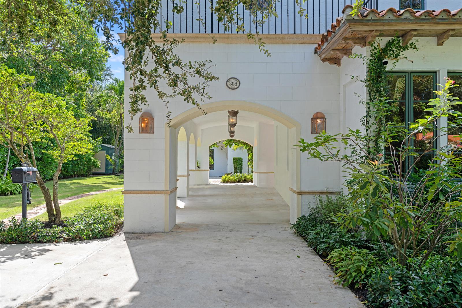 A white stucco arched breezeway leads to a garden area with hanging lanterns — 308 BARCELONA Road, West Palm Beach FL 33401, WEST PALM BEACH, FL