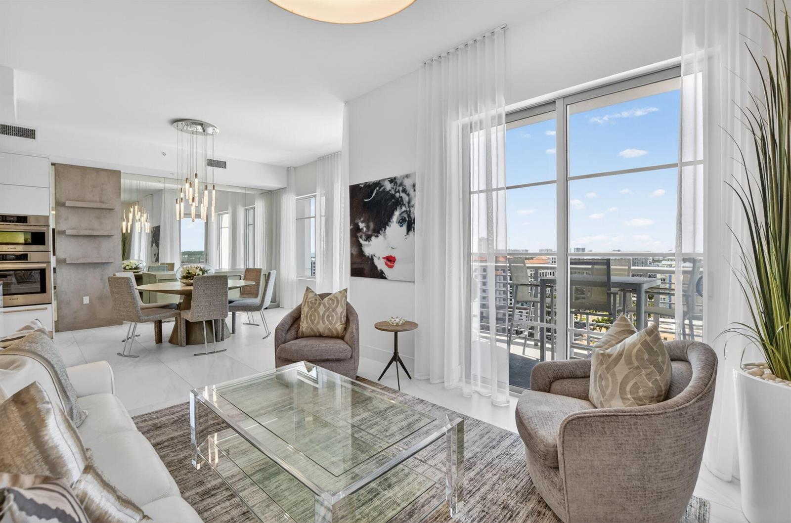 A modern living and dining area with white tile floors, glass furniture, and balcony access — 155 E Boca Raton Road # 1201, Boca Raton FL 33432, BOCA RATON, FL