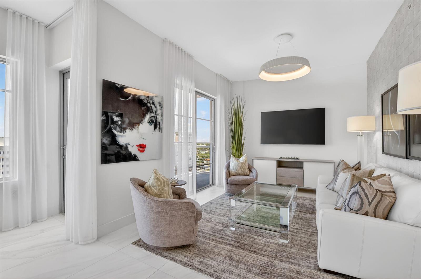 A modern living room features a white sofa, two armchairs, a glass table, and artwork — 155 E Boca Raton Road # 1201, Boca Raton FL 33432, BOCA RATON, FL