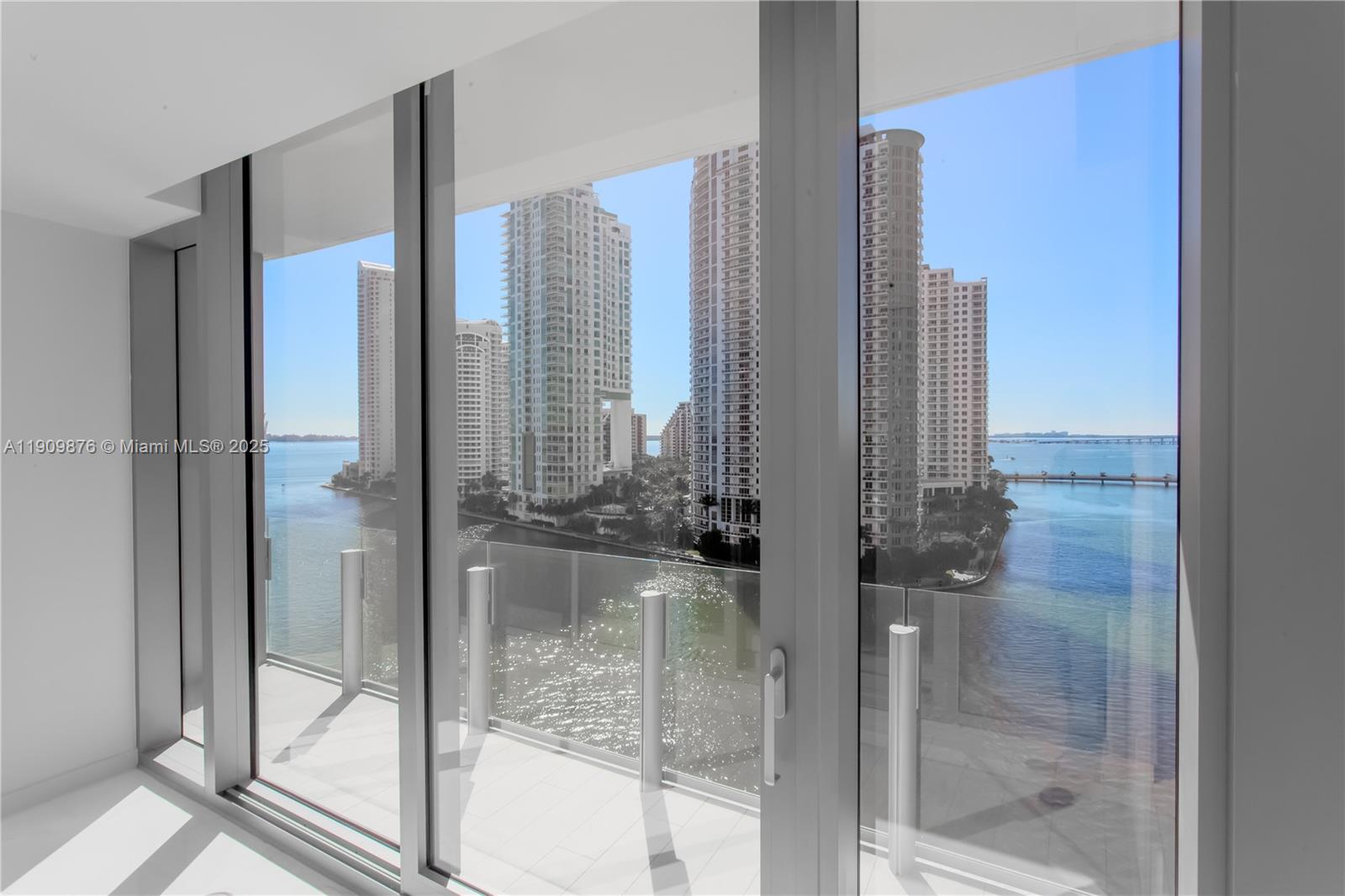 A view of a waterfront city skyline from a room with floor-to-ceiling glass doors — 300 Biscayne Blvd Way # 1003, Miami FL 33131, MIAMI, FL