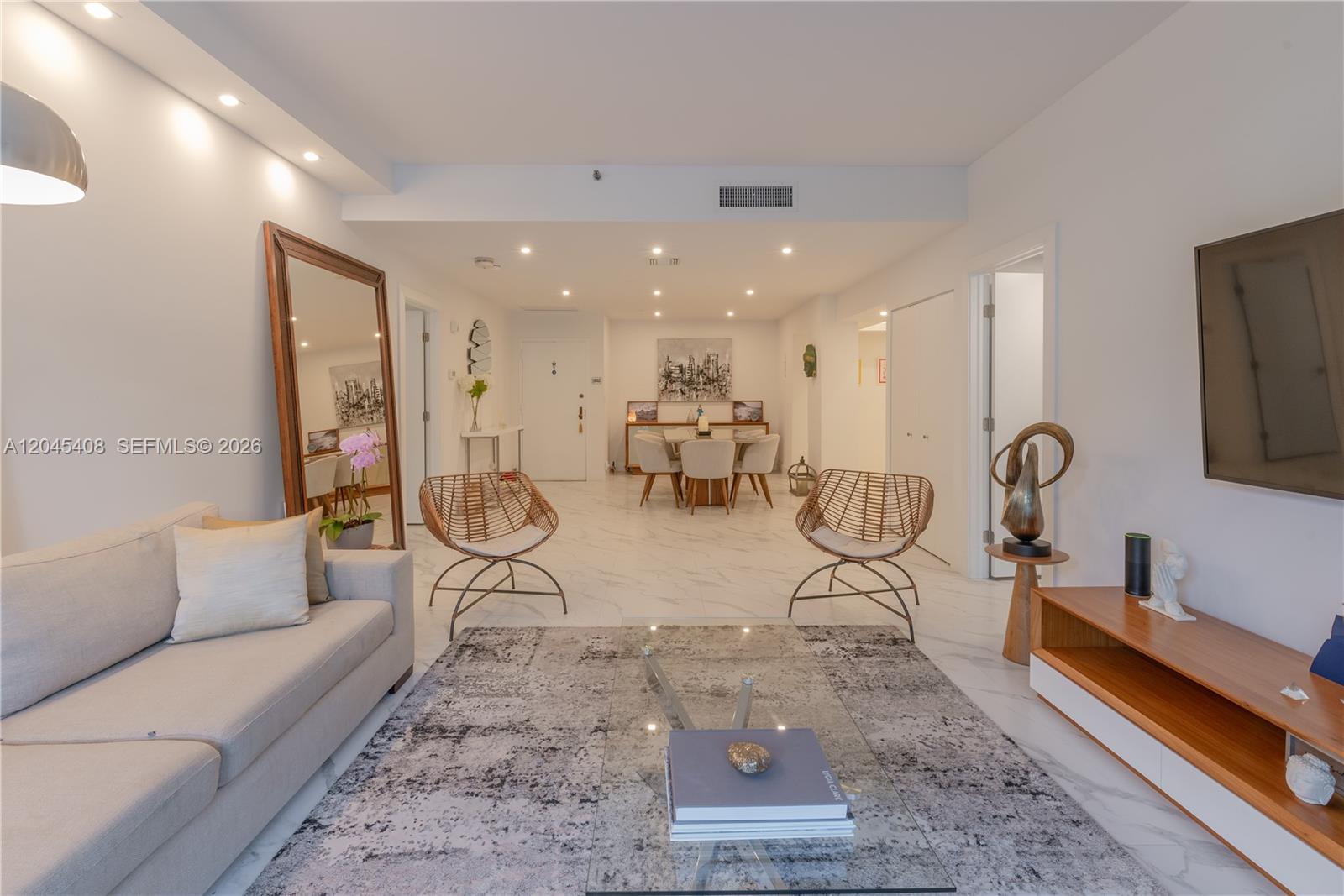 A living room features a light sofa, two wicker chairs, and marble flooring — 151 Crandon Blvd # 122, Key Biscayne FL 33149, KEY BISCAYNE, FL