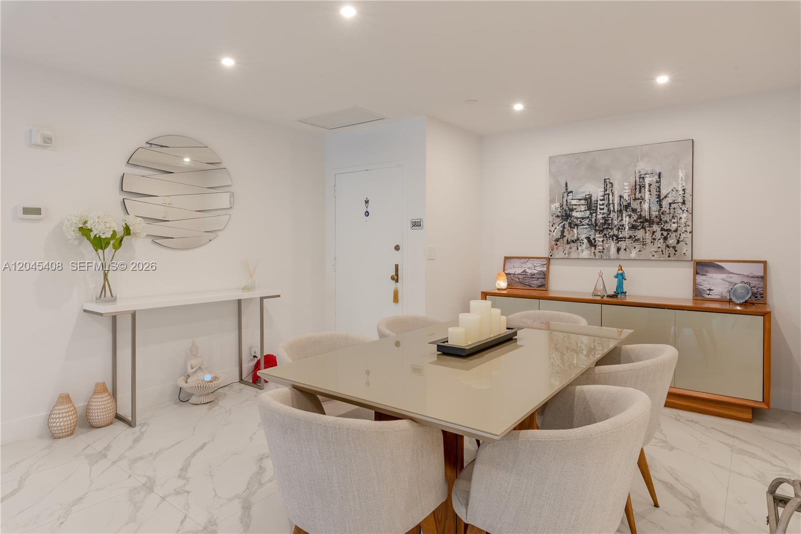 A dining room features a glass-topped table, upholstered chairs, marble flooring, and a large mirror — 151 Crandon Blvd # 122, Key Biscayne FL 33149, KEY BISCAYNE, FL