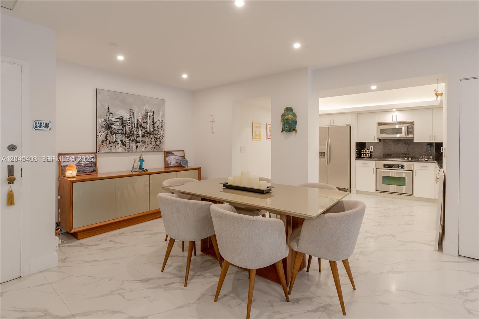 A dining area with a glass table and chairs sits adjacent to a modern kitchen — 151 Crandon Blvd # 122, Key Biscayne FL 33149, KEY BISCAYNE, FL