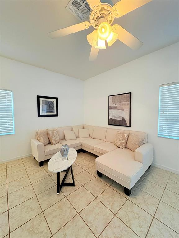 A living room features a beige sectional sofa, a marble-topped coffee table, and tiled floors — 4573 ADA LANE, KISSIMMEE, FL
