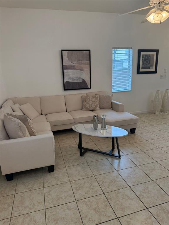 A living room features a beige sectional sofa, a marble coffee table, and tiled floors — 4573 ADA LANE, KISSIMMEE, FL