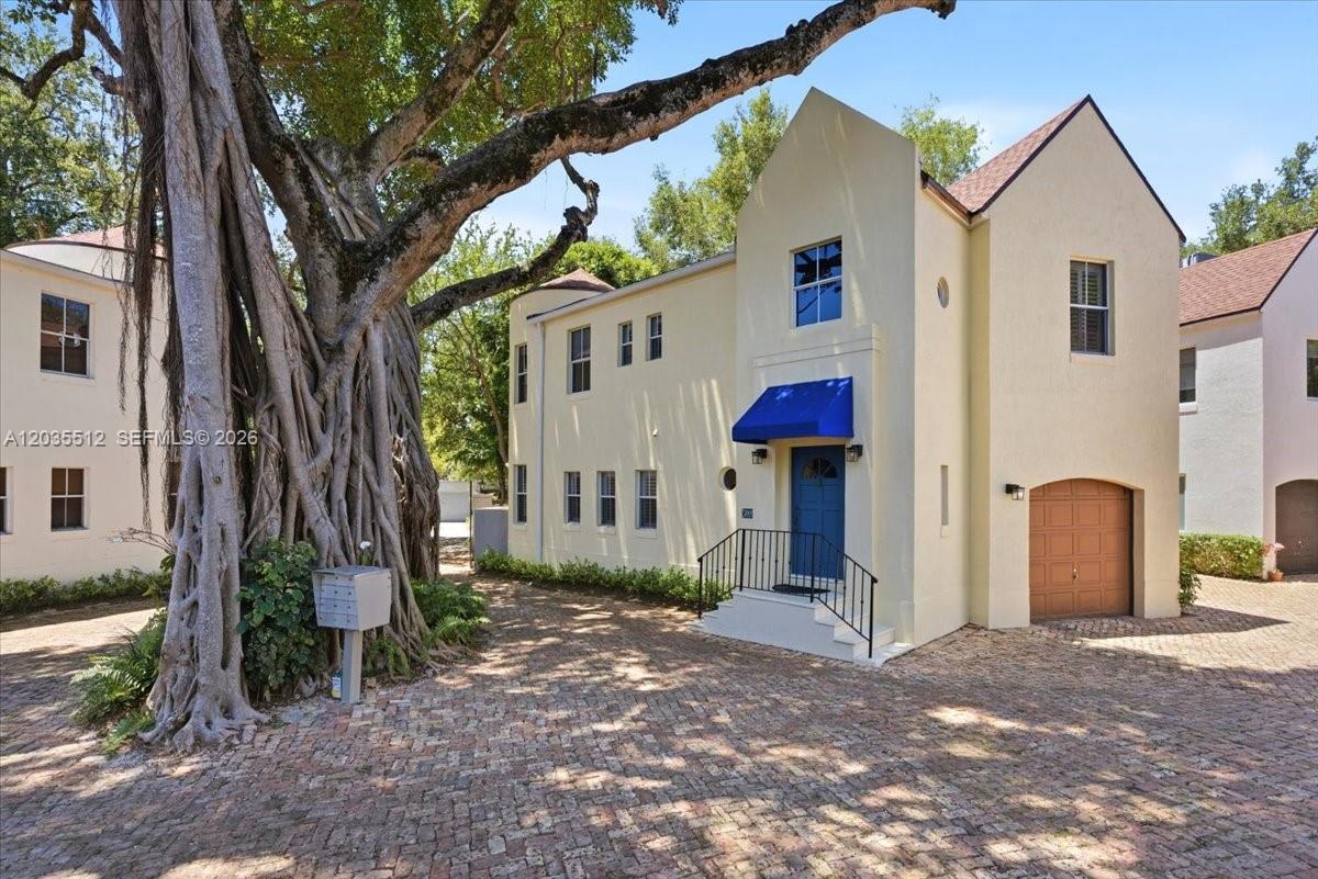 A two-story stucco house with a blue awning and a large tree in front — 2917 Jackson Ave, Miami FL 33133, MIAMI, FL