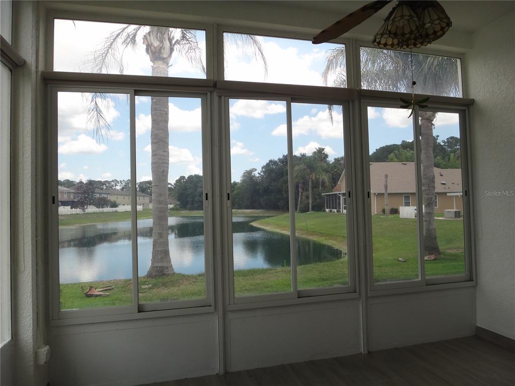 A view of a pond surrounded by suburban houses and a grassy lawn — 2614 CAITHNESS WAY, CLERMONT, FL