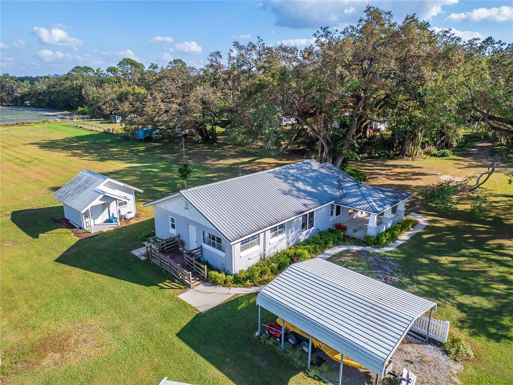 An aerial view shows a house with a metal roof, a detached shed, and a carport — 5020 SYDNEY ROAD, PLANT CITY, FL