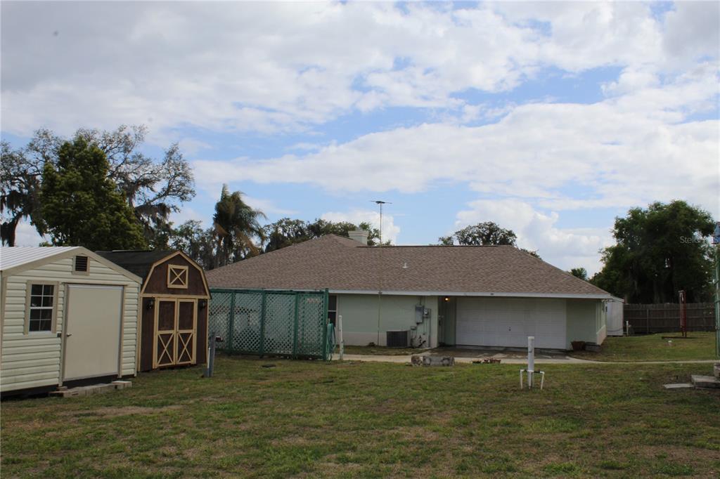 A single-story house with a light-colored exterior, a large front window, and a concrete walkway — 38901 ELLA DRIVE, LADY LAKE, FL