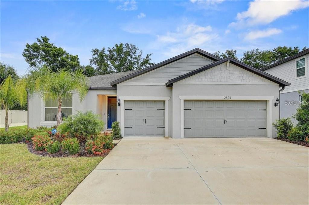 A single-story house with a gray exterior, a three-car garage, and a palm tree — 2824 QUAIL CREST COURT, VALRICO, FL