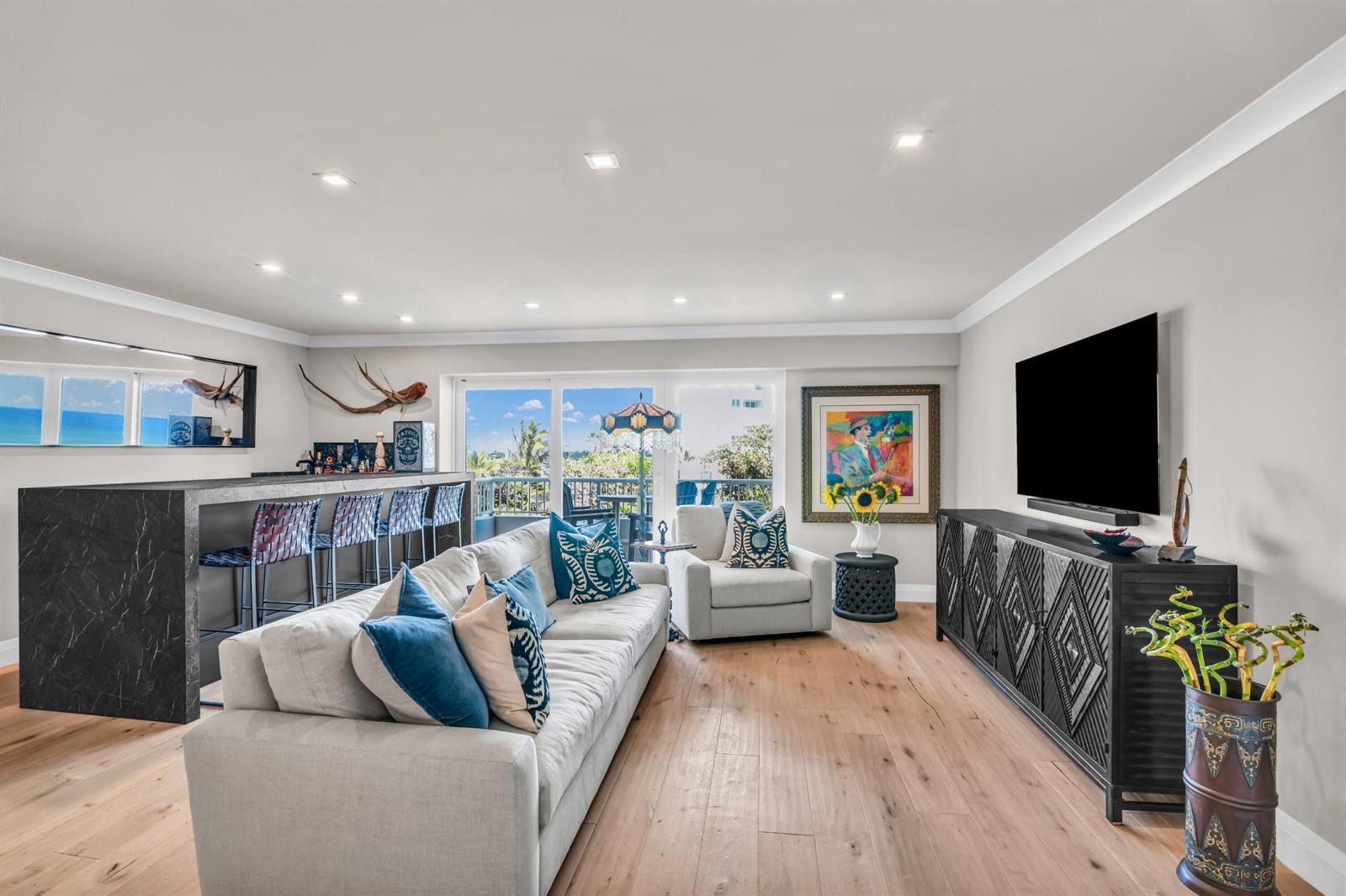 A living room features a marble bar, a sofa, a television, and a balcony view — 600 S Ocean Boulevard # 407, Boca Raton FL 33432, BOCA RATON, FL