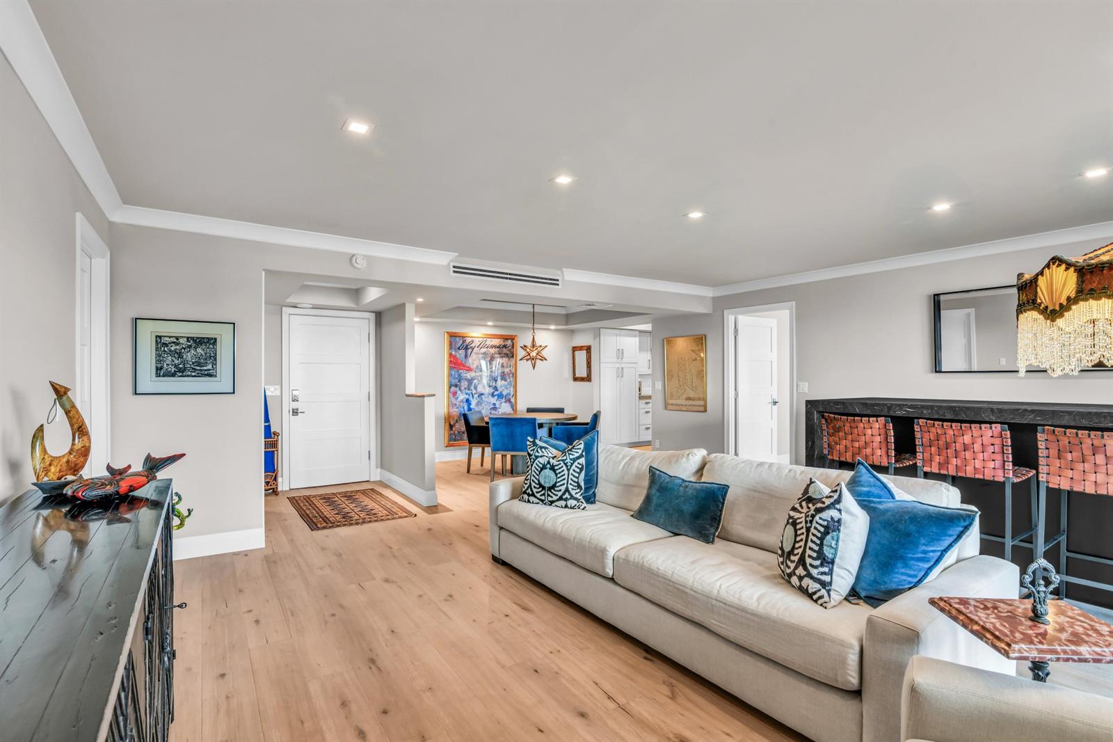 A living room features light wood floors, a white sofa with blue pillows, and a bar — 600 S Ocean Boulevard # 407, Boca Raton FL 33432, BOCA RATON, FL