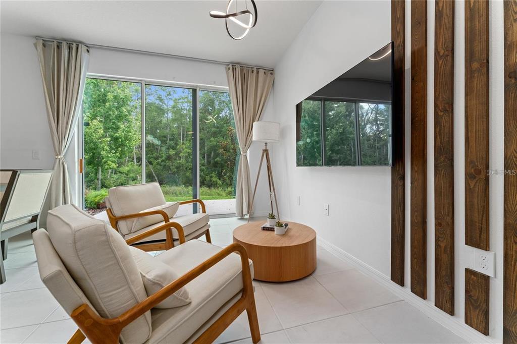 A living room features two armchairs, a round coffee table, and a wall-mounted television — 2125 CRYSTAL BELL STREET, ORLANDO, FL