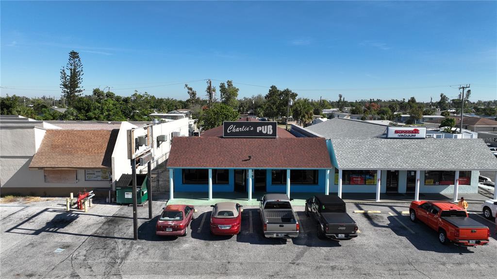 An exterior view of a commercial strip mall featuring Charlie's Pub and a vacuum store — 3496 TAMIAMI TRAIL, PORT CHARLOTTE, FL