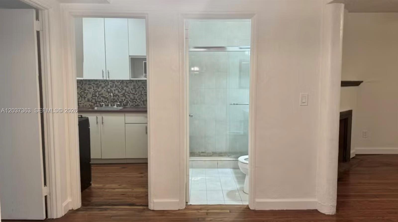 A view through two doorways shows a kitchen with white cabinets and a tiled bathroom — 751 Euclid Ave # 2, Miami Beach FL 33139, MIAMI BEACH, FL