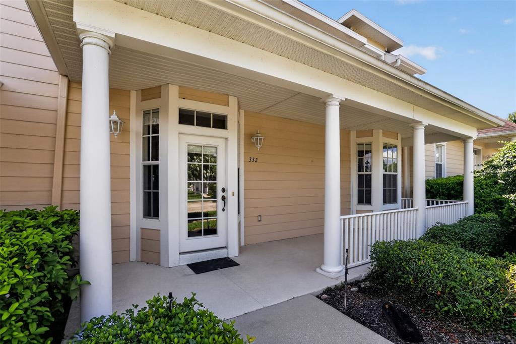 A covered front porch with white columns leads to a glass-paneled door on a house — 332 NAUTICA MILE DRIVE, CLERMONT, FL